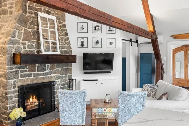 a living room with furniture a flat screen tv and a fireplace