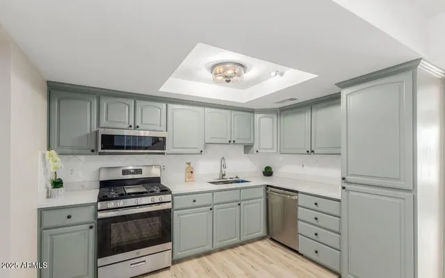 a kitchen with cabinets stainless steel appliances and a counter space