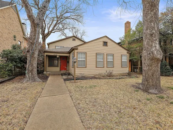 a front view of a house with a yard and trees