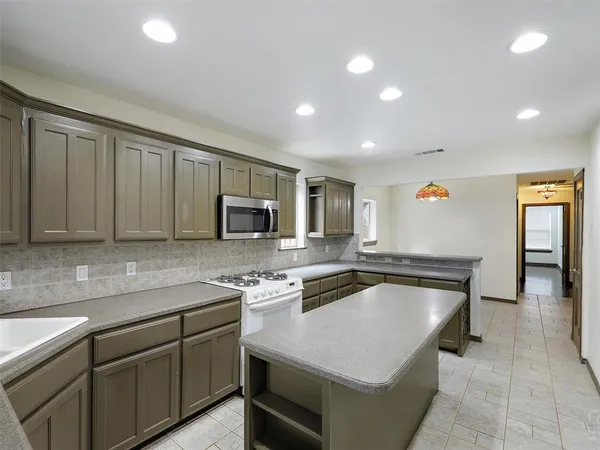 a kitchen that has a sink a microwave and a stove