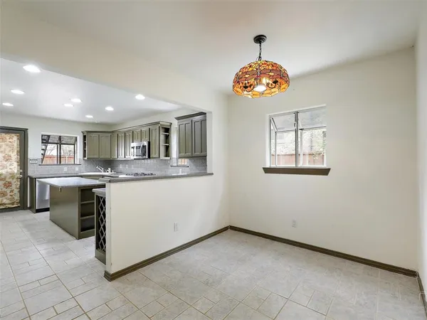 a view of kitchen with granite countertop cabinets and window