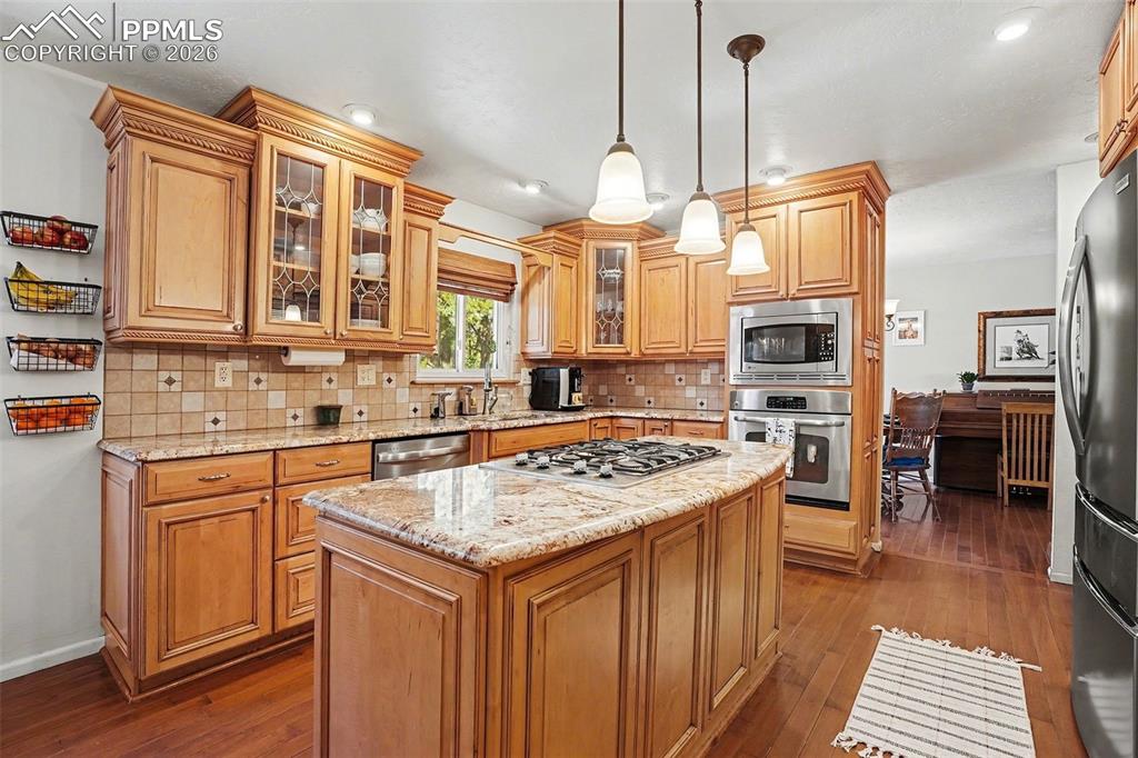 8265 Tannenbaum Road Colorado Springs, CO 80908 - Photo 12 of 50 a kitchen with stainless steel appliances granite countertop a sink a stove and a refrigerator