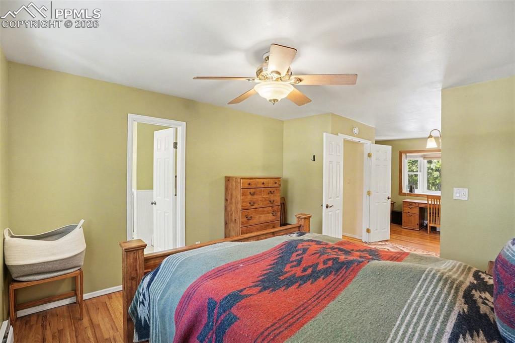 8265 Tannenbaum Road Colorado Springs, CO 80908 - Photo 19 of 50 a bedroom with a bed chandelier and a window