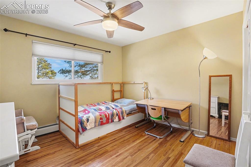 8265 Tannenbaum Road Colorado Springs, CO 80908 - Photo 24 of 50 a bedroom with a bed and a chandelier