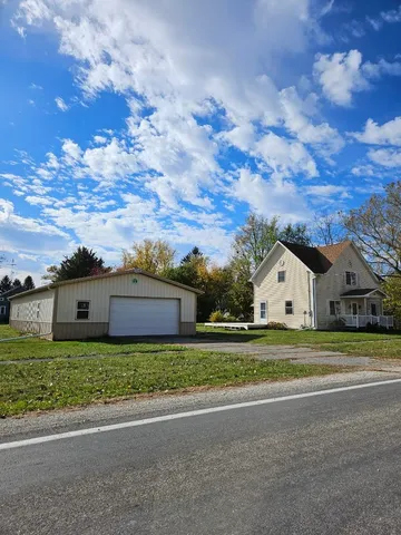 a view of a house with a big yard and large trees