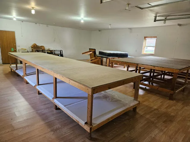 a room with stainless steel appliances kitchen island a wooden floor and chairs