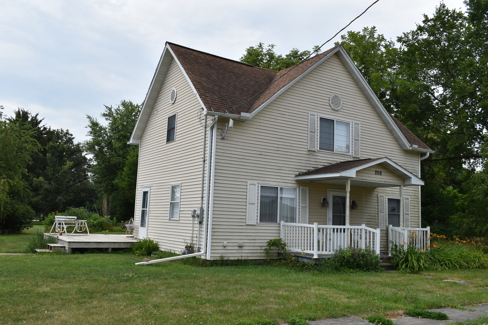 208 East Washington Street Dana, IL 61321 - Photo 6 of 28 a view of a white house with a yard and a garden