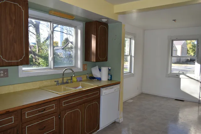 a kitchen with a sink a window and cabinets