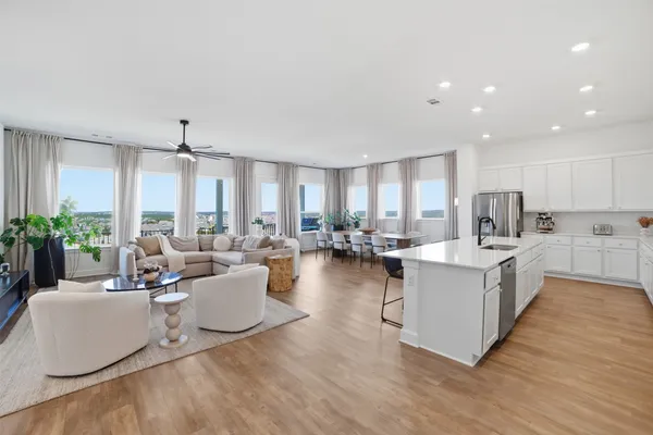 a large white kitchen with a large window and stainless steel appliances