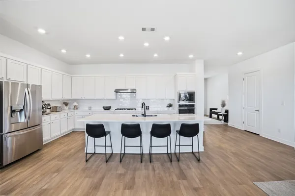 a living room with furniture a large window and wooden floors