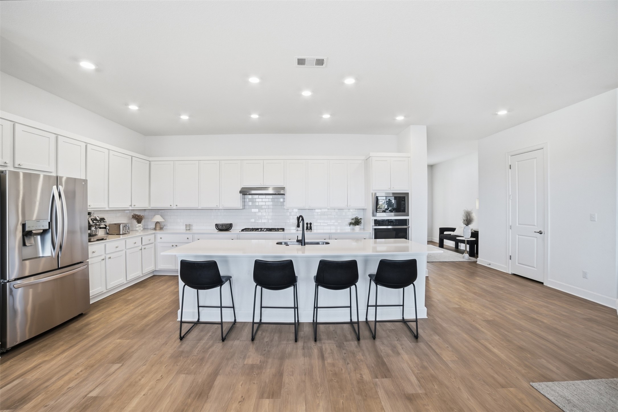 256 Smoke Tree Circle Dripping Springs, TX 78620 - Photo 11 of 40 a kitchen with a dining table chairs refrigerator and cabinets