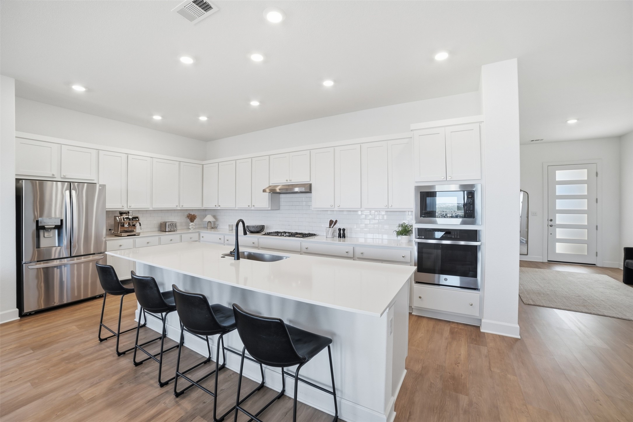 256 Smoke Tree Circle Dripping Springs, TX 78620 - Photo 12 of 40 a kitchen with stainless steel appliances kitchen island granite countertop a refrigerator and a stove top oven