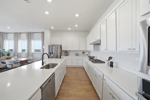 a kitchen with stainless steel appliances kitchen island granite countertop a refrigerator and a stove top oven