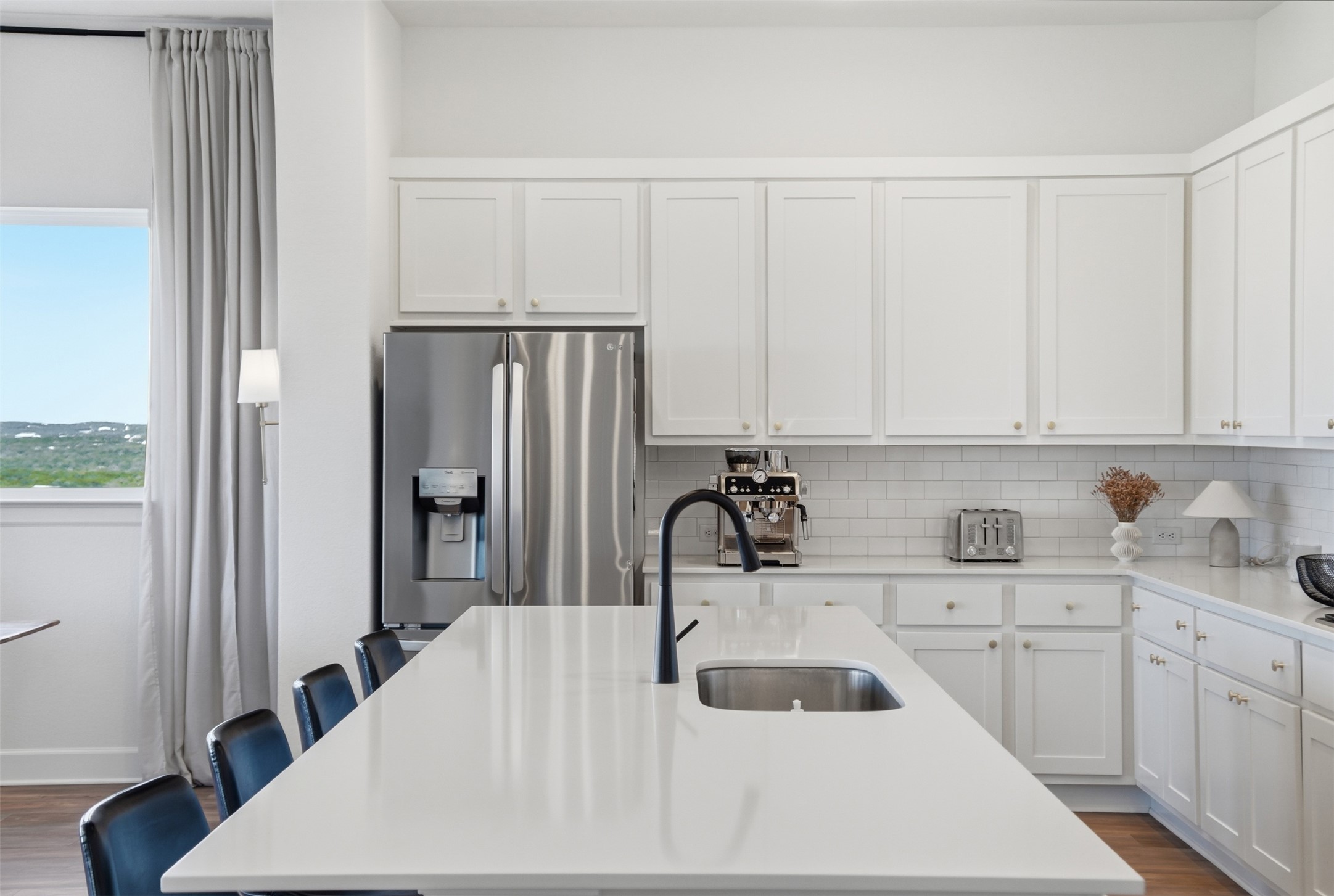 256 Smoke Tree Circle Dripping Springs, TX 78620 - Photo 14 of 40 a kitchen with white cabinets and stainless steel appliances