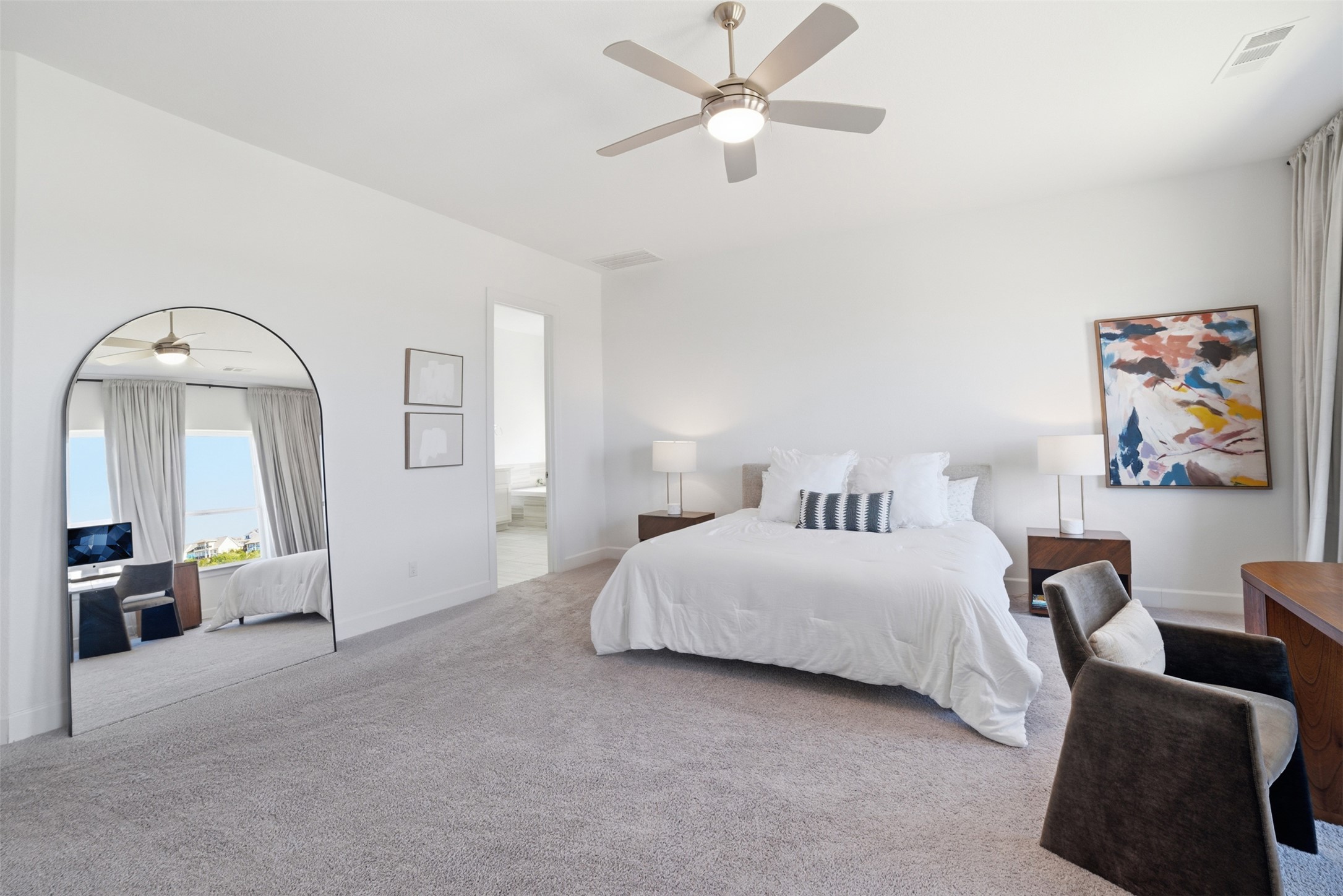 256 Smoke Tree Circle Dripping Springs, TX 78620 - Photo 20 of 40 a spacious bedroom with a bed a couch and a chandelier fan