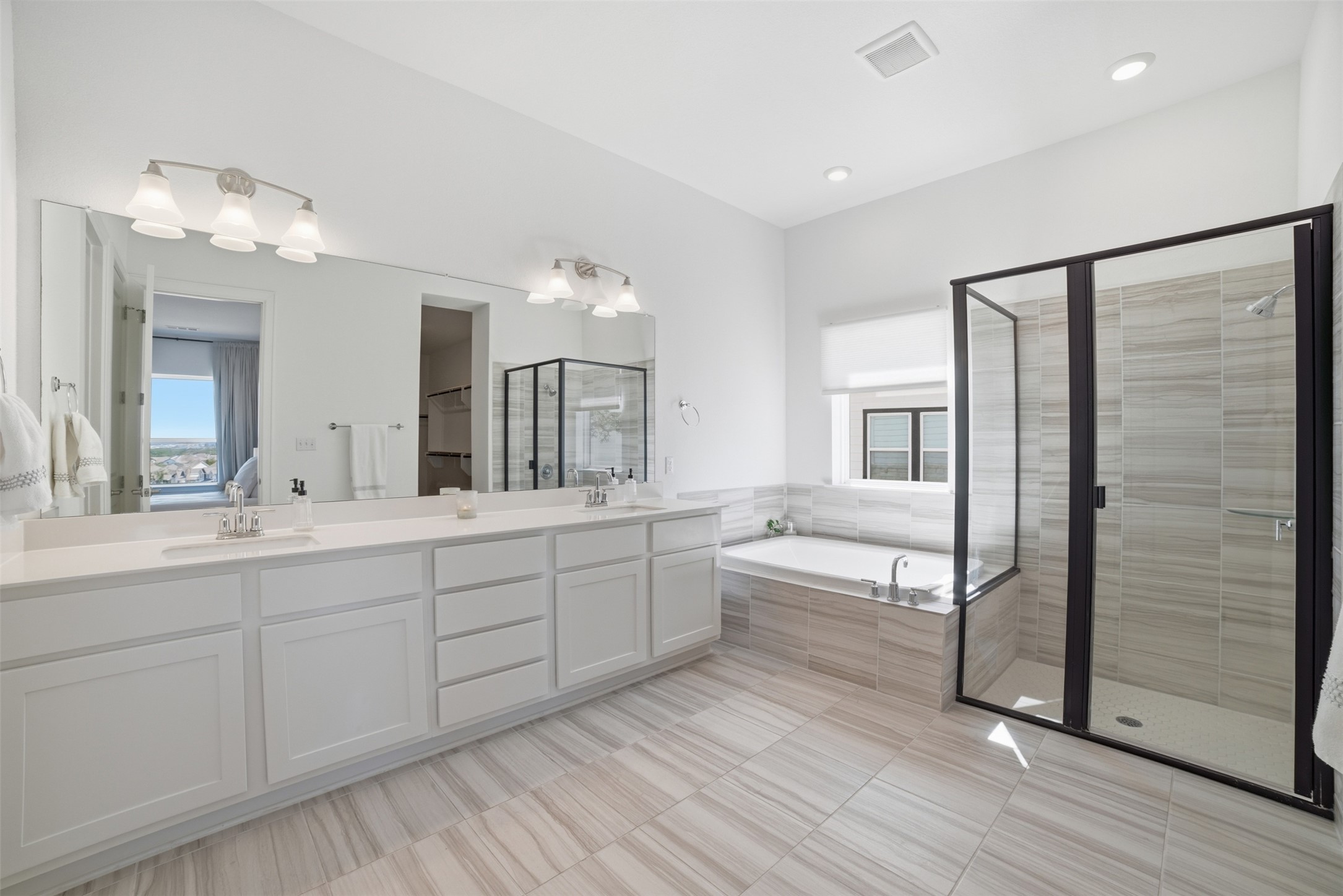 256 Smoke Tree Circle Dripping Springs, TX 78620 - Photo 21 of 40 a bathroom with a double vanity sink a mirror and a bathtub