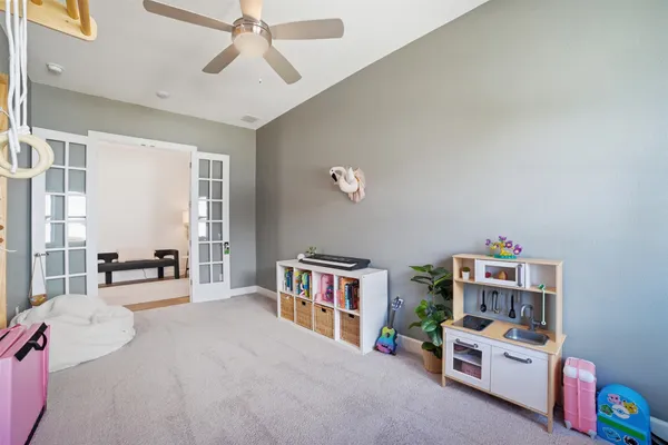a bedroom with a bed wooden floor and a large window