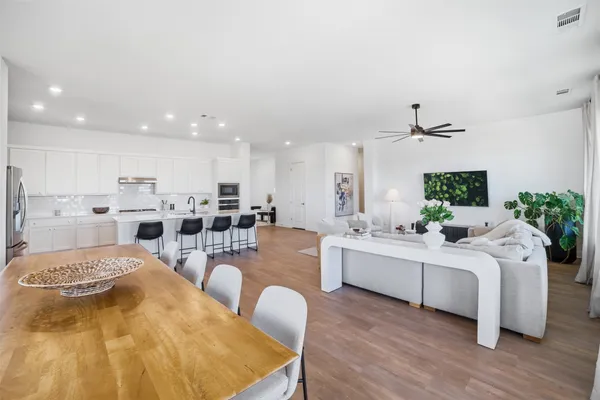a large white kitchen with a large window a sink and stainless steel appliances