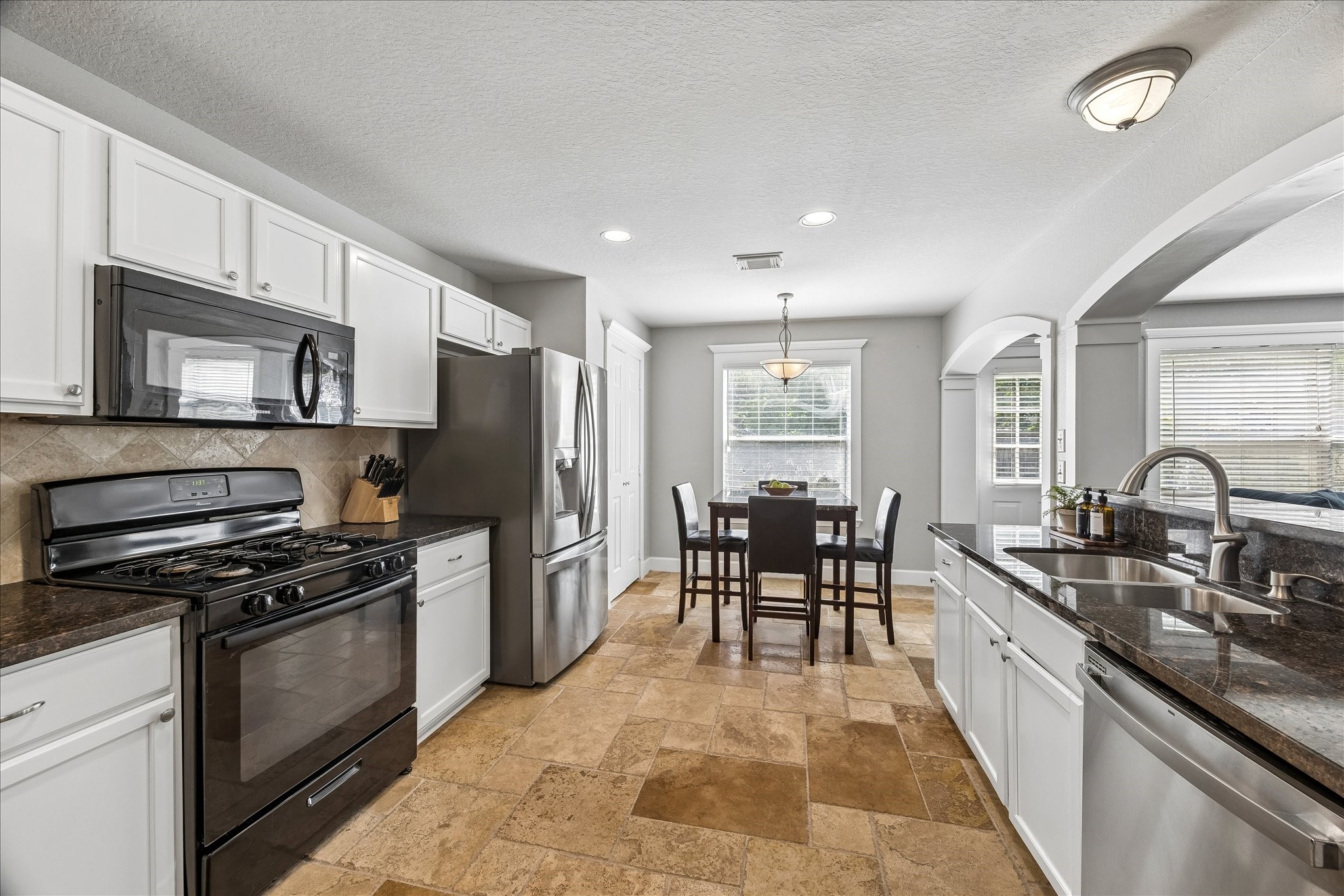 23234 Grand Rapids Lane Spring, TX 77373 - Photo 10 of 30 Open kitchen with granite counterrops and stainless appliances overlookks a sunlit breakfast nook - the heart of the home.