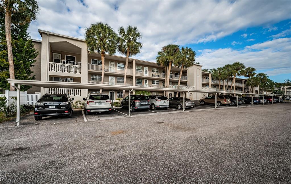 920 Virginia Street, Unit 302 Dunedin, FL 34698 - Photo 4 of 66 a car parked in front of a house with a yard