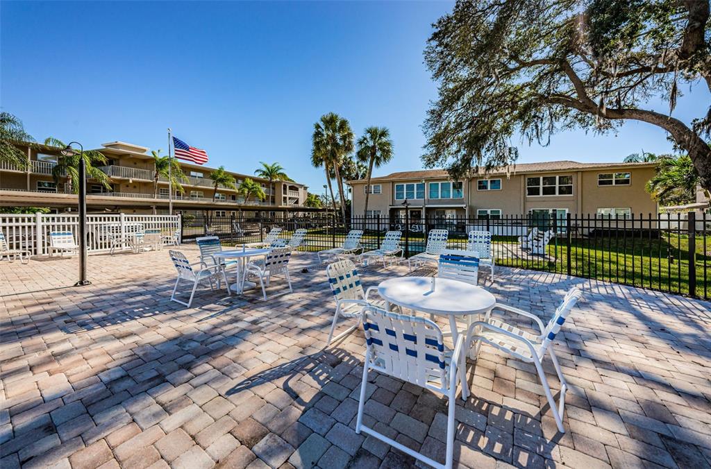 920 Virginia Street, Unit 302 Dunedin, FL 34698 - Photo 44 of 66 a view of a patio with couches and table and chairs and potted plants