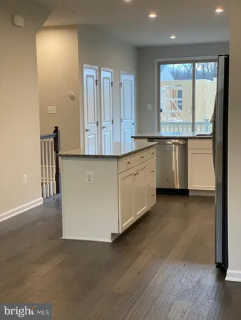 a view of a large kitchen with a sink wooden floor and windows