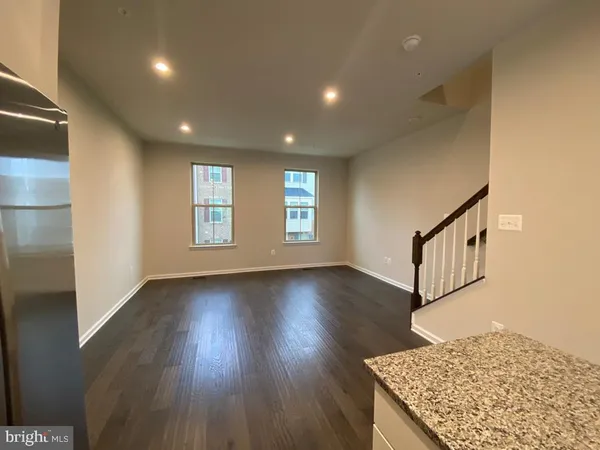 an entryway in a hall with wooden floor and a window