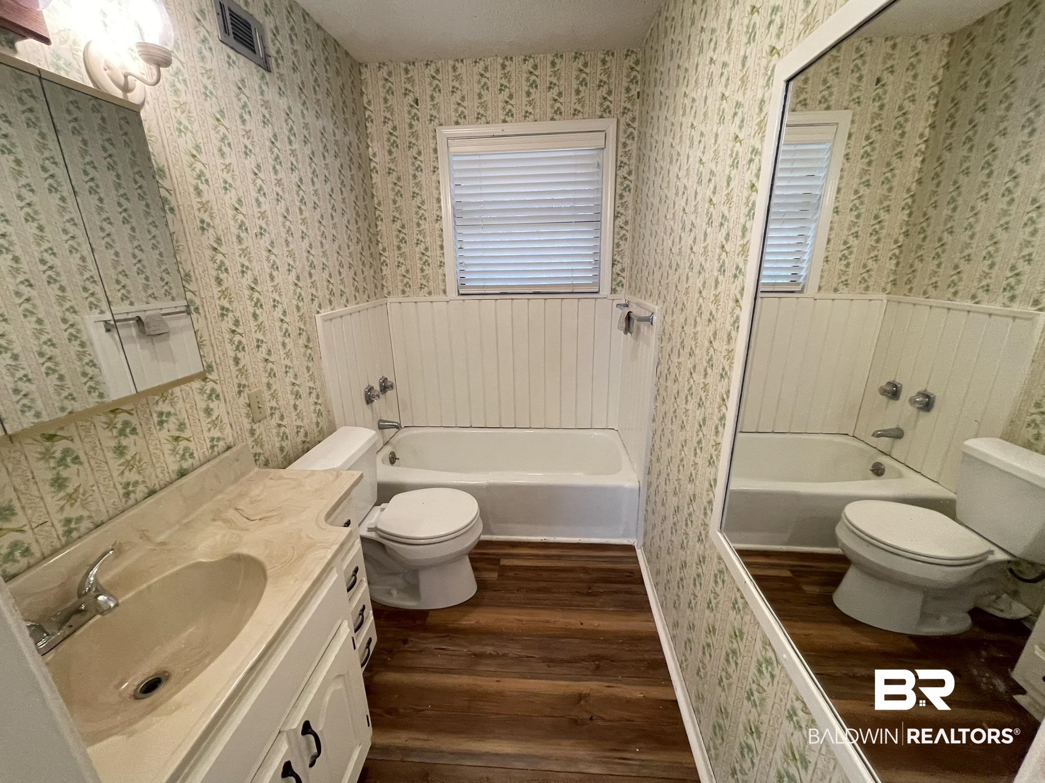 6621 Purvis Road Daphne, AL 36527 - Photo 45 of 59 Bathroom with wallpapered walls, a bath, dark wood-style floors, and vanity
