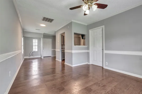 a view of empty room with wooden floor and ceiling fan