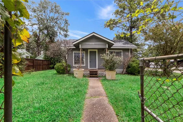 a front view of a house with yard and green space