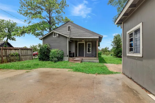 a view of a house with a yard and large tree