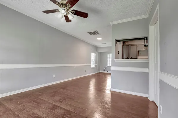 wooden floor in an empty room with a kitchen