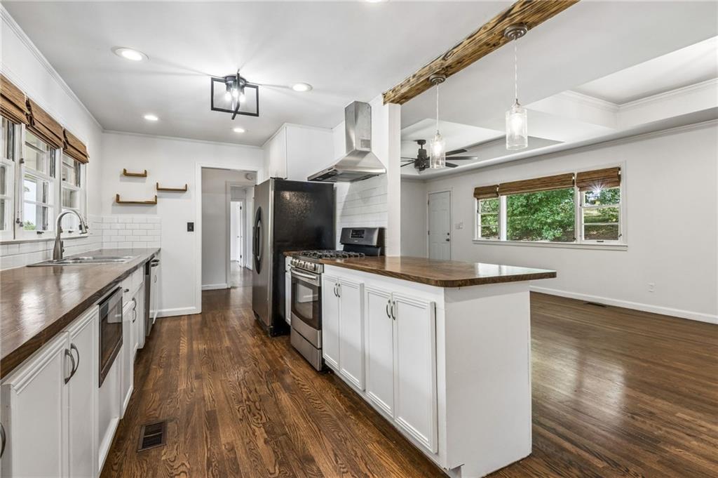 358 Peevy Street Buford, GA 30518 - Photo 6 of 18 a kitchen with granite countertop a sink cabinets stainless steel appliances and a large window