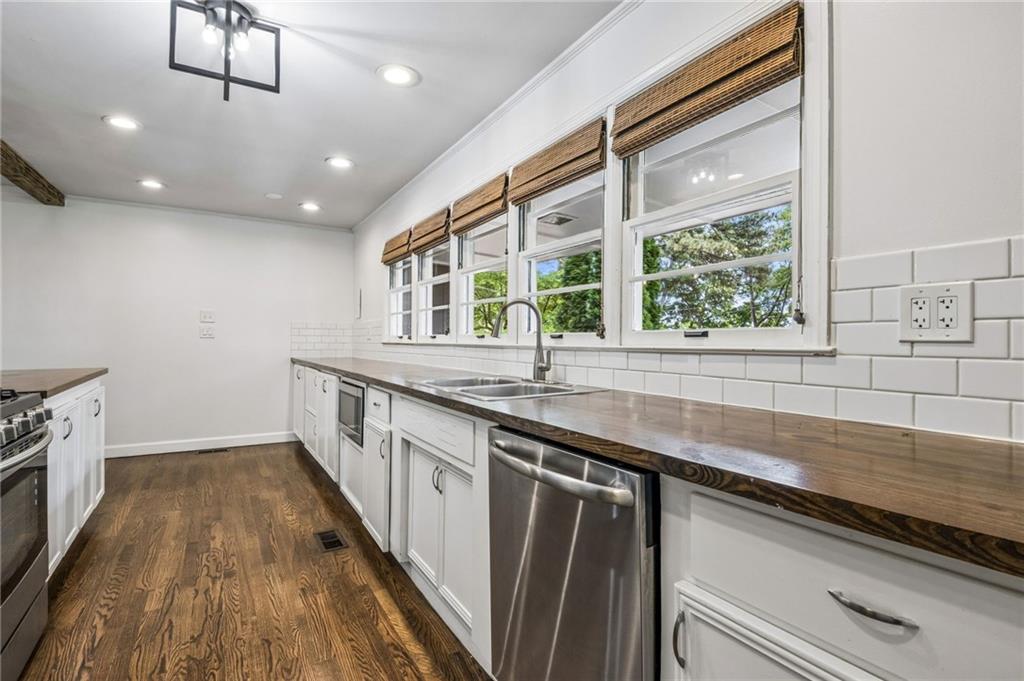 358 Peevy Street Buford, GA 30518 - Photo 7 of 18 a kitchen with stainless steel appliances granite countertop a sink a stove and a wooden floors