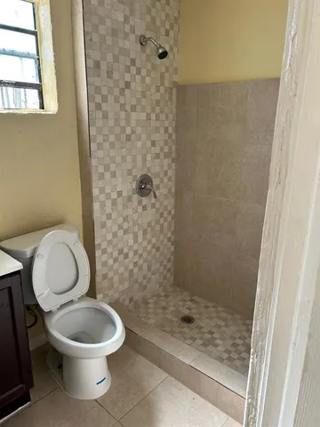 a white toilet sitting next to a shower
