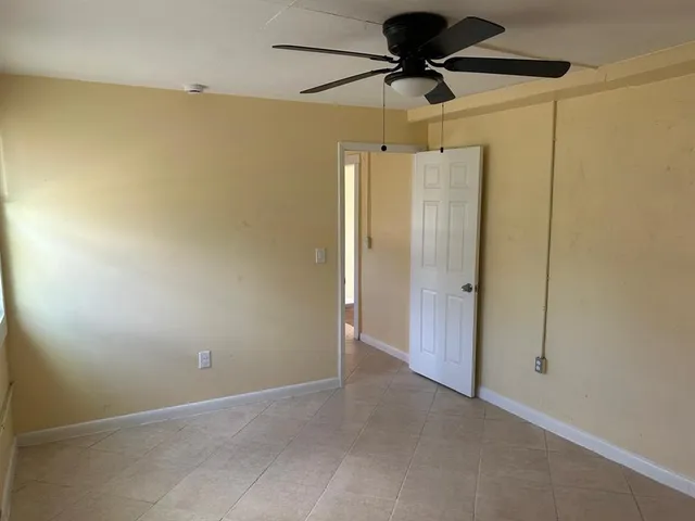 en empty room with a ceiling fan and shower