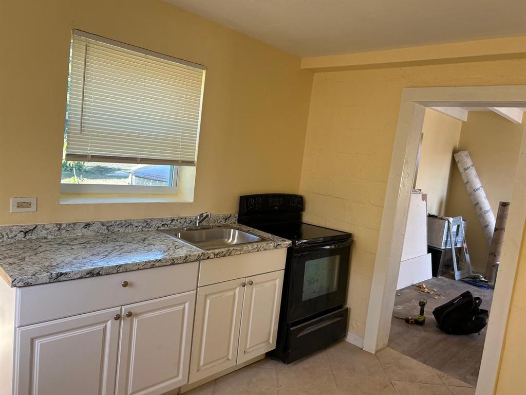 371 Banyan Avenue Pahokee, FL 33476 - Photo 8 of 12 a bathroom with a granite countertop sink and a window