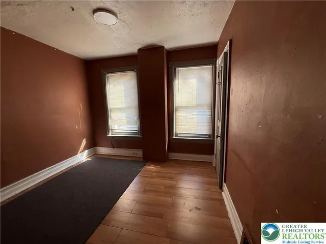 a view of hallway with a large window and wooden floor