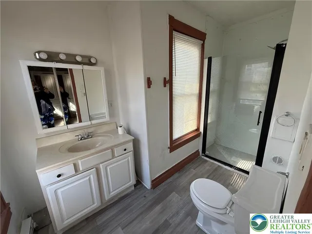 a bathroom with a granite countertop toilet sink and mirror