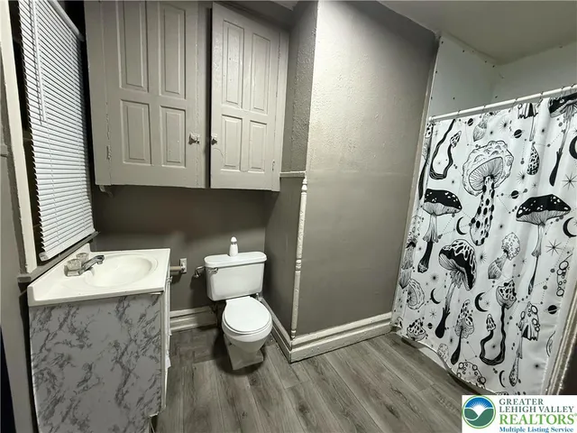 a bathroom with a toilet and a shower curtain