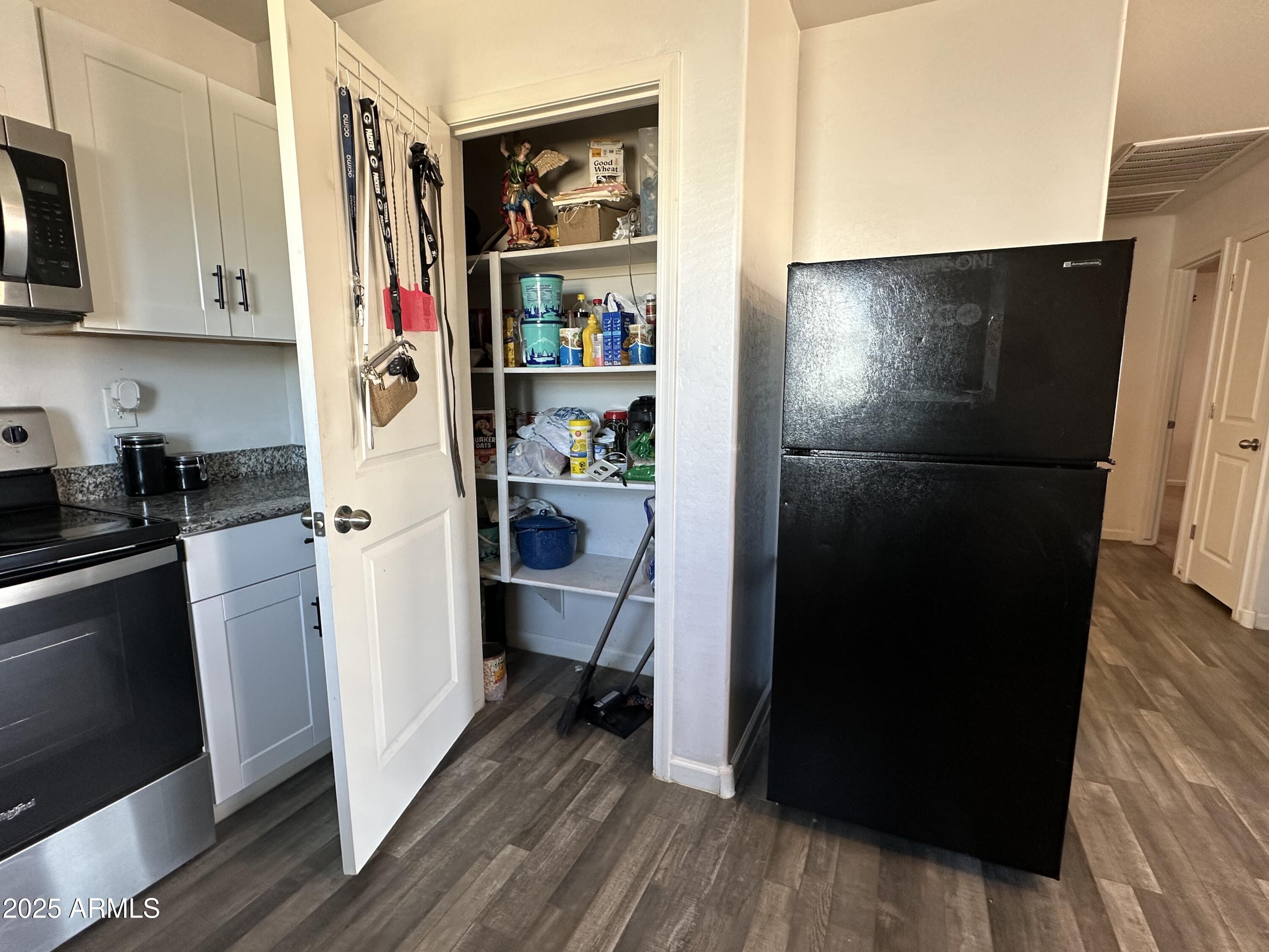 14852 South Diablo Road Arizona City, AZ 85123 - Photo 27 of 30 a room with refrigerator and wooden floor