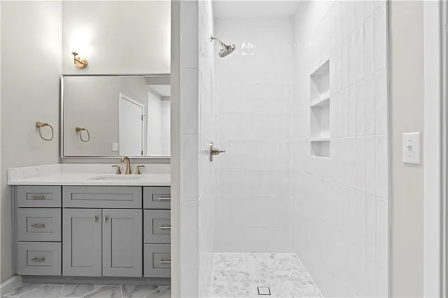 a bathroom with a granite countertop sink a mirror and a shower
