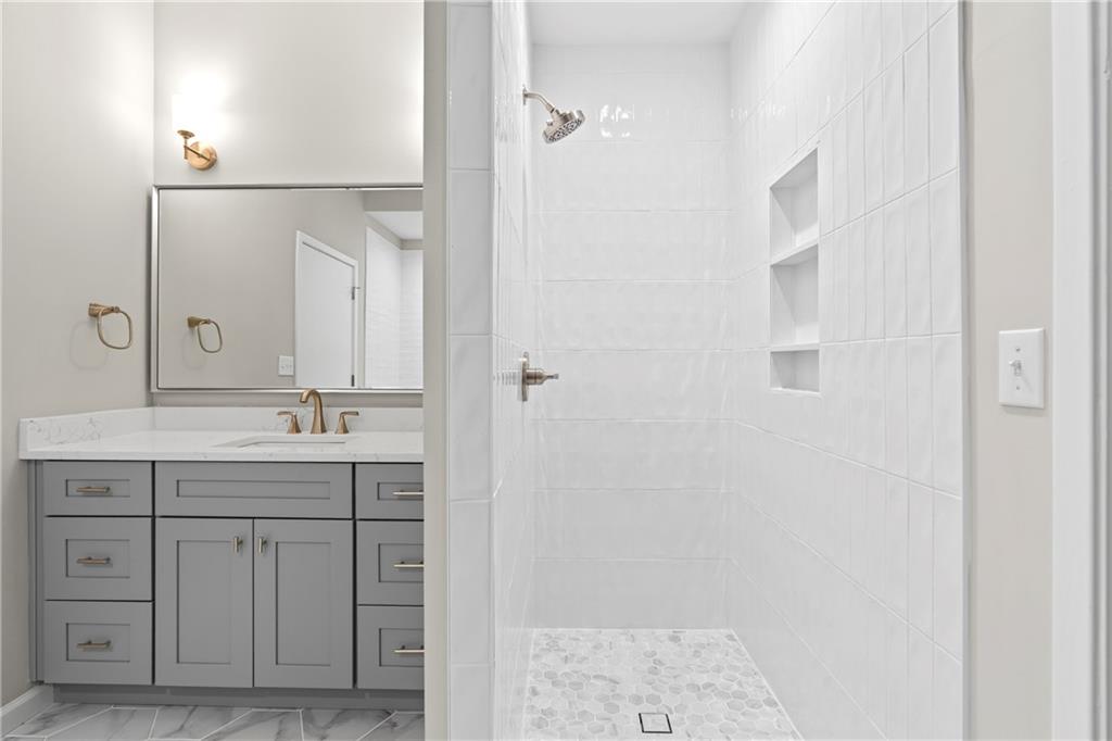 5300 Peachtree Road, Unit 3308 Atlanta, GA 30341 - Photo 20 of 45 a bathroom with a granite countertop sink a mirror and a shower