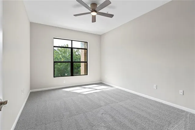an empty room with a window and a fan