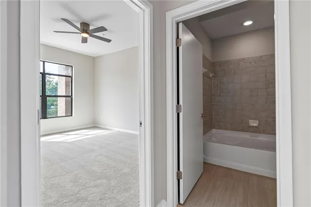 a view of an empty room and a bathroom with a bathtub