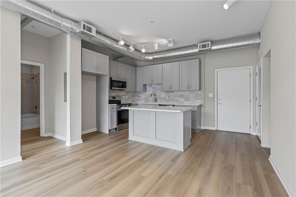 5300 Peachtree Road, Unit 3308 Atlanta, GA 30341 - Photo 4 of 45 a kitchen with stainless steel appliances granite countertop a white cabinets and wooden floor