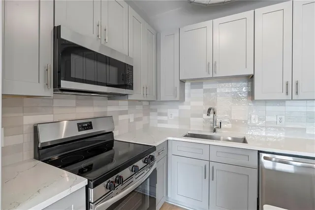 a kitchen with appliances a sink and cabinets