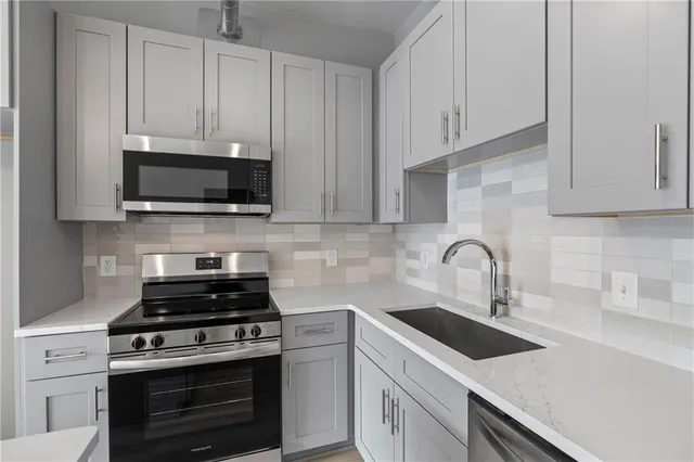 a kitchen with cabinets appliances a sink and a counter top