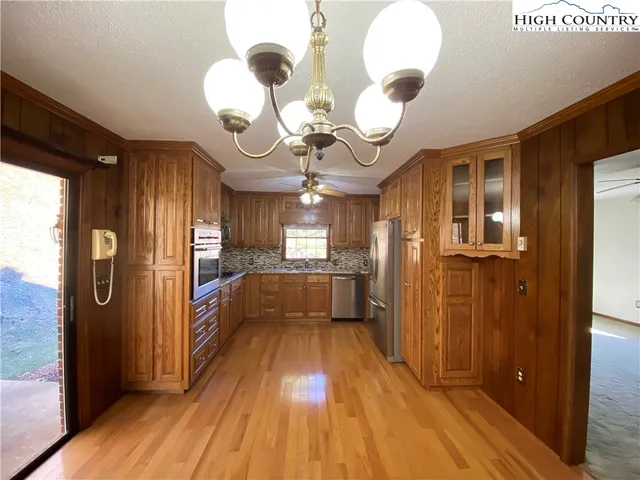a kitchen with granite countertop wooden cabinets stainless steel appliances and a window