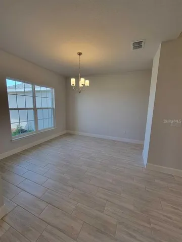 an empty room with windows and fireplace